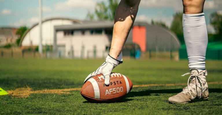 Close-up of an athlete on a football field preparing to snap the ball, showcasing intense focus and athleticism.