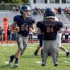 Adult custom American football uniform in a sophisticated grey and navy color scheme featuring reinforced mesh and padding slots.